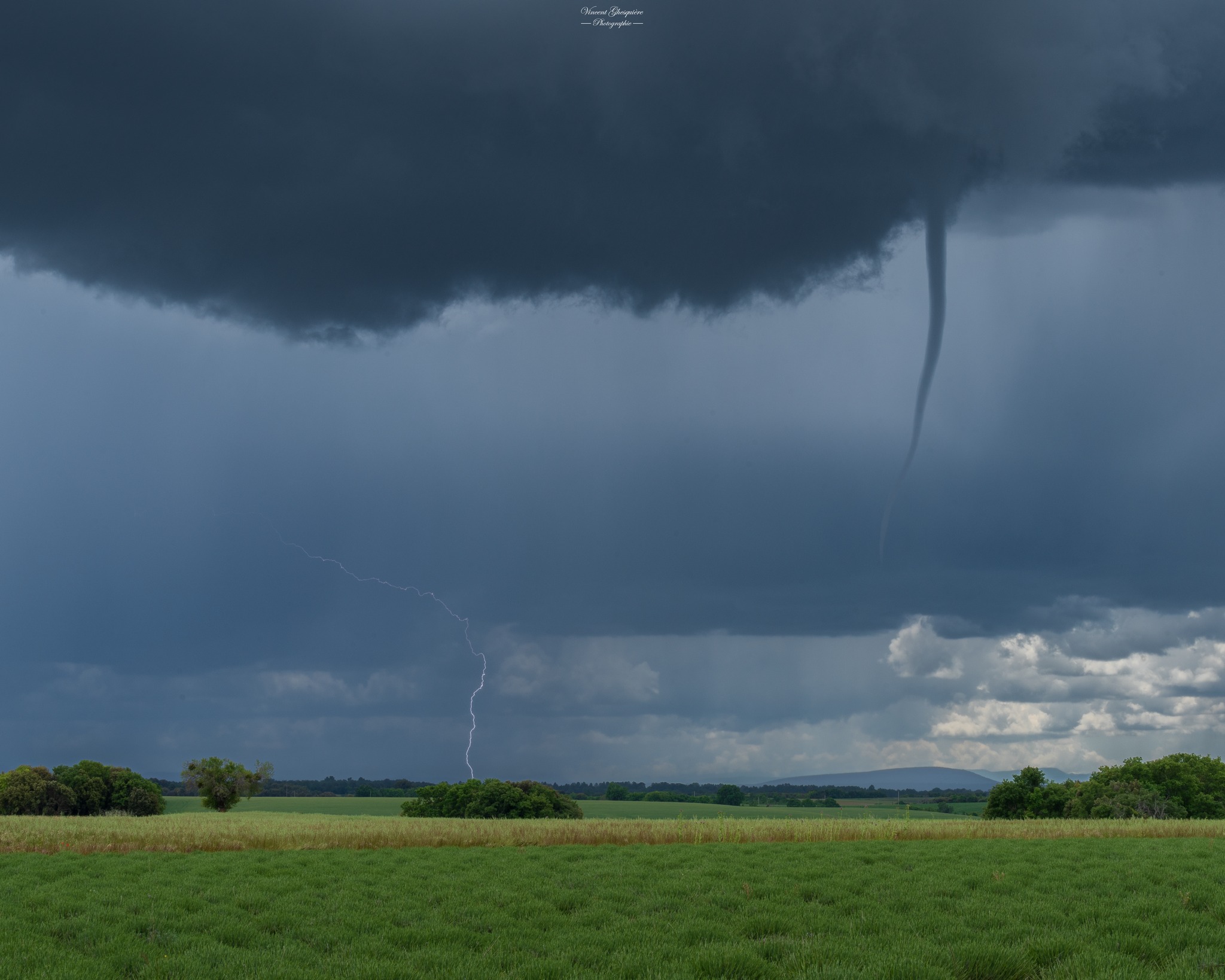 <p>Un très long tuba s'est formé ce samedi midi sur le plateau de Valensole (Alpes-de-Haute-Provence), photographié ici avec chute de foudre à l'arrière-plan par V. Ghesquiere.</p>