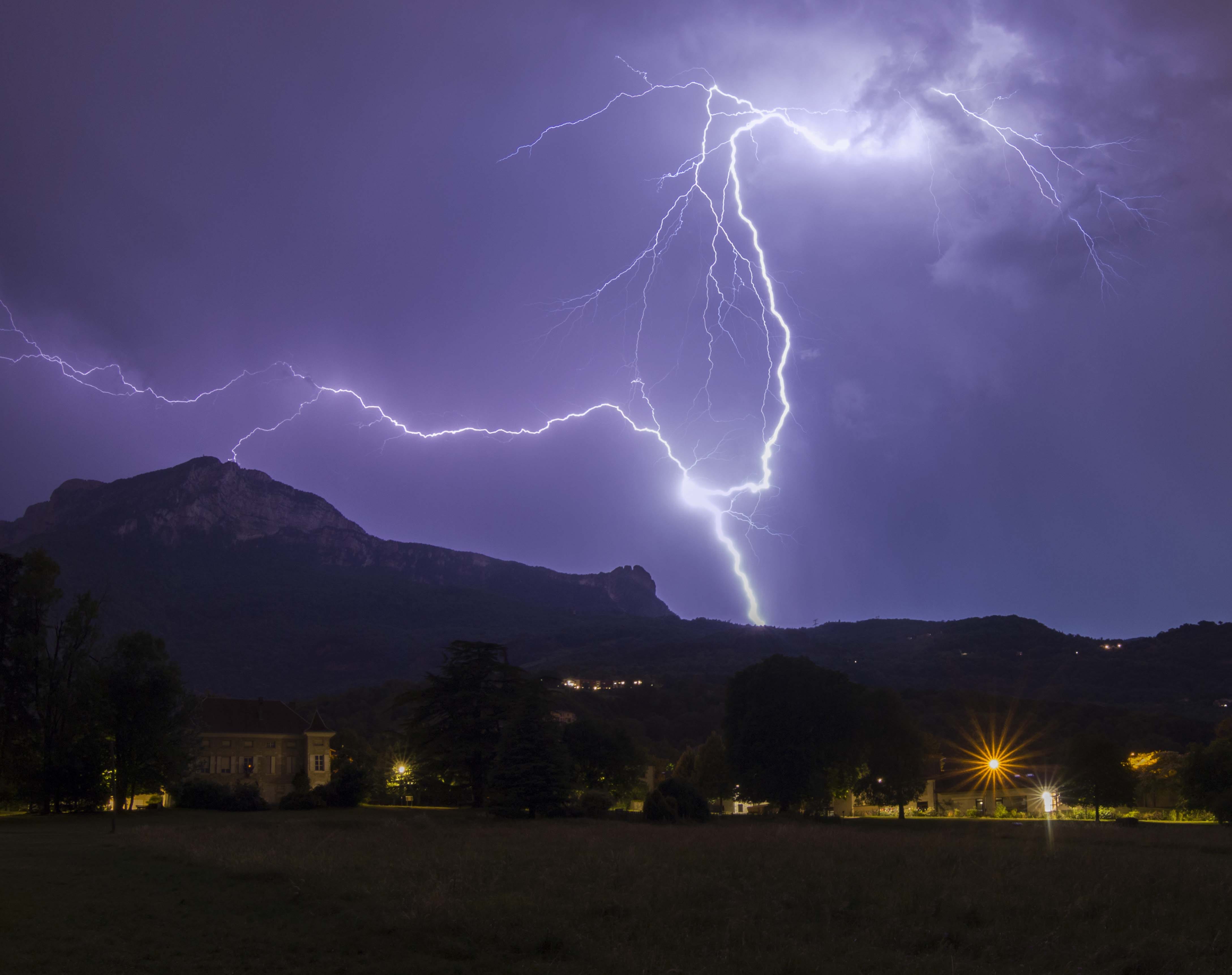 Orage très puissant (plusieurs impacts positifs en poche) et bref  au dessus du Moucherotte et des trois pucelles dans le Vercors et qui à fini sa course sur Grenoble. Premier plan ,la mairie de Seyssins. Isère - 15/06/2022 22:00 - frederic sanchis