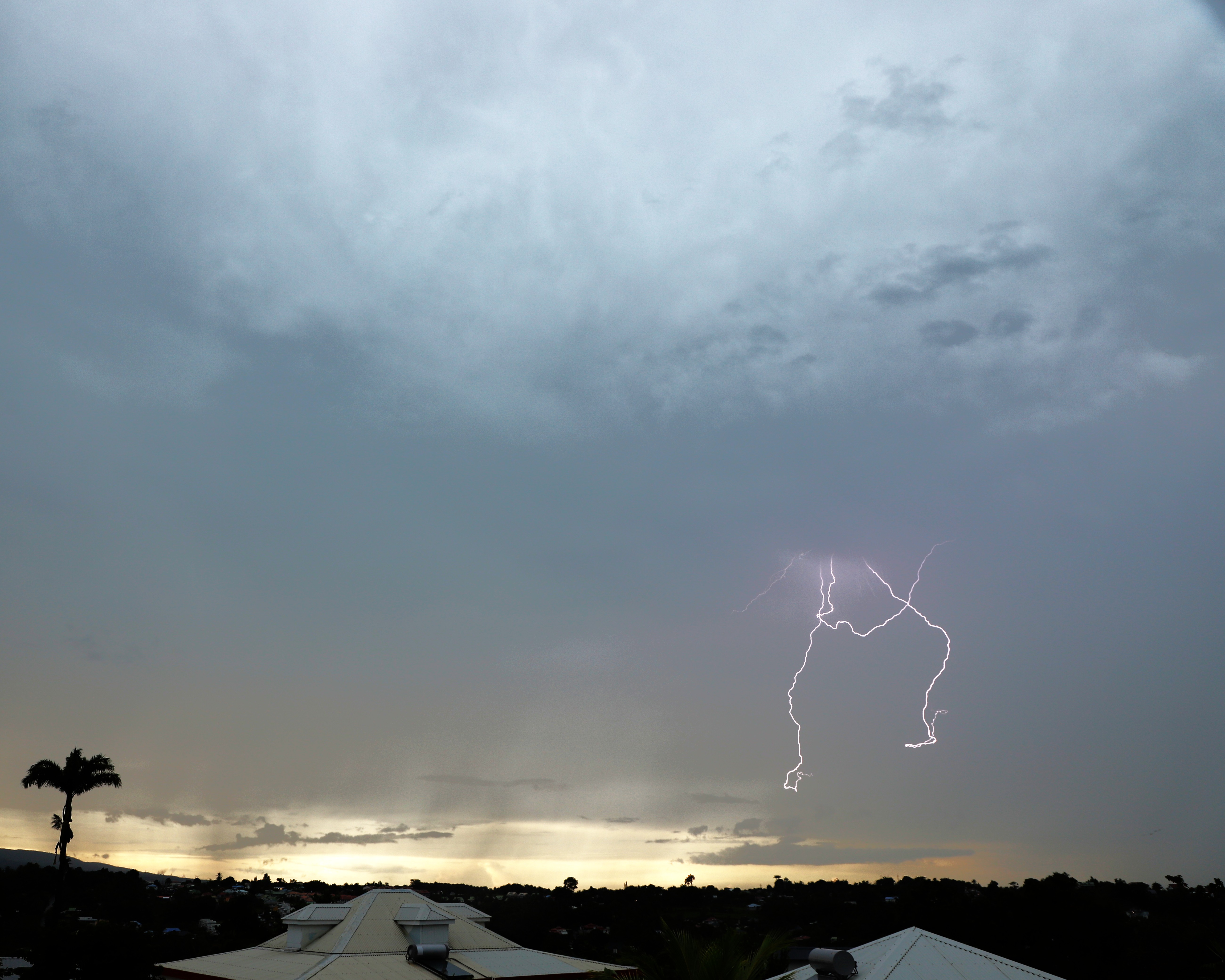 Décharge kéraunique isolée de forte intensité zébrant le ciel guadeloupéen. Photo réalisée depuis la commune de Baie-Mahault (971).
Contexte: descente et passage d'un front froid pluvio-orageux sur le Nord des Petites Antilles associé à un flux de Sud, modéré et instable faisant remonter des cellules pluvio-orageuses voire orageuses sur l'archipel de la Guadeloupe. - 16/10/2025 17:01 - Saint-Clément Steeve