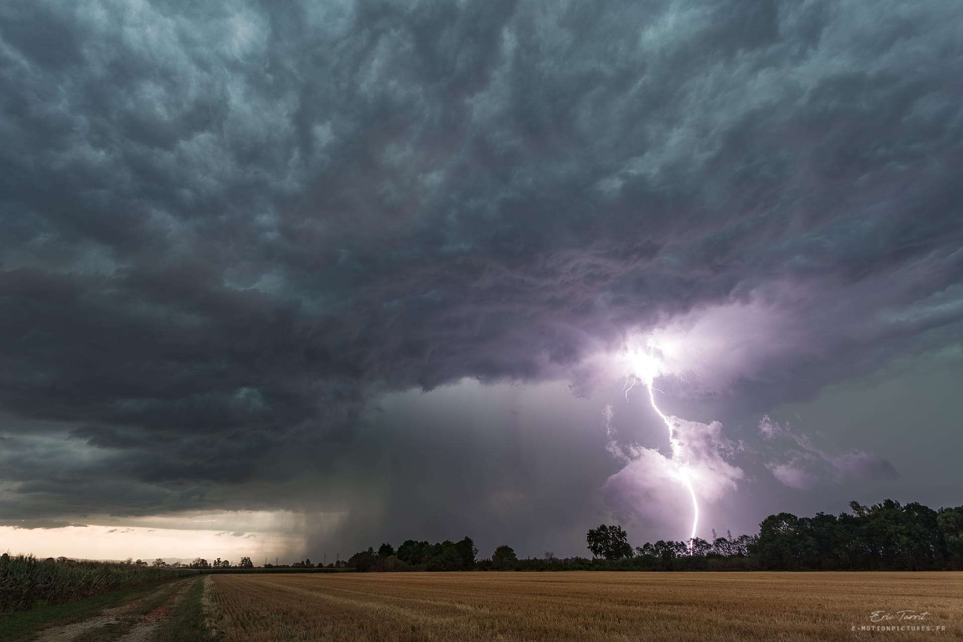 Orage violent sur le secteur de Pusignan. Rafales descendantes accompagnées d'un coup de foudre traversant des fractus d'ascendance, sous un ciel de mort. - 01/08/2020 19:16 - Eric TARRIT