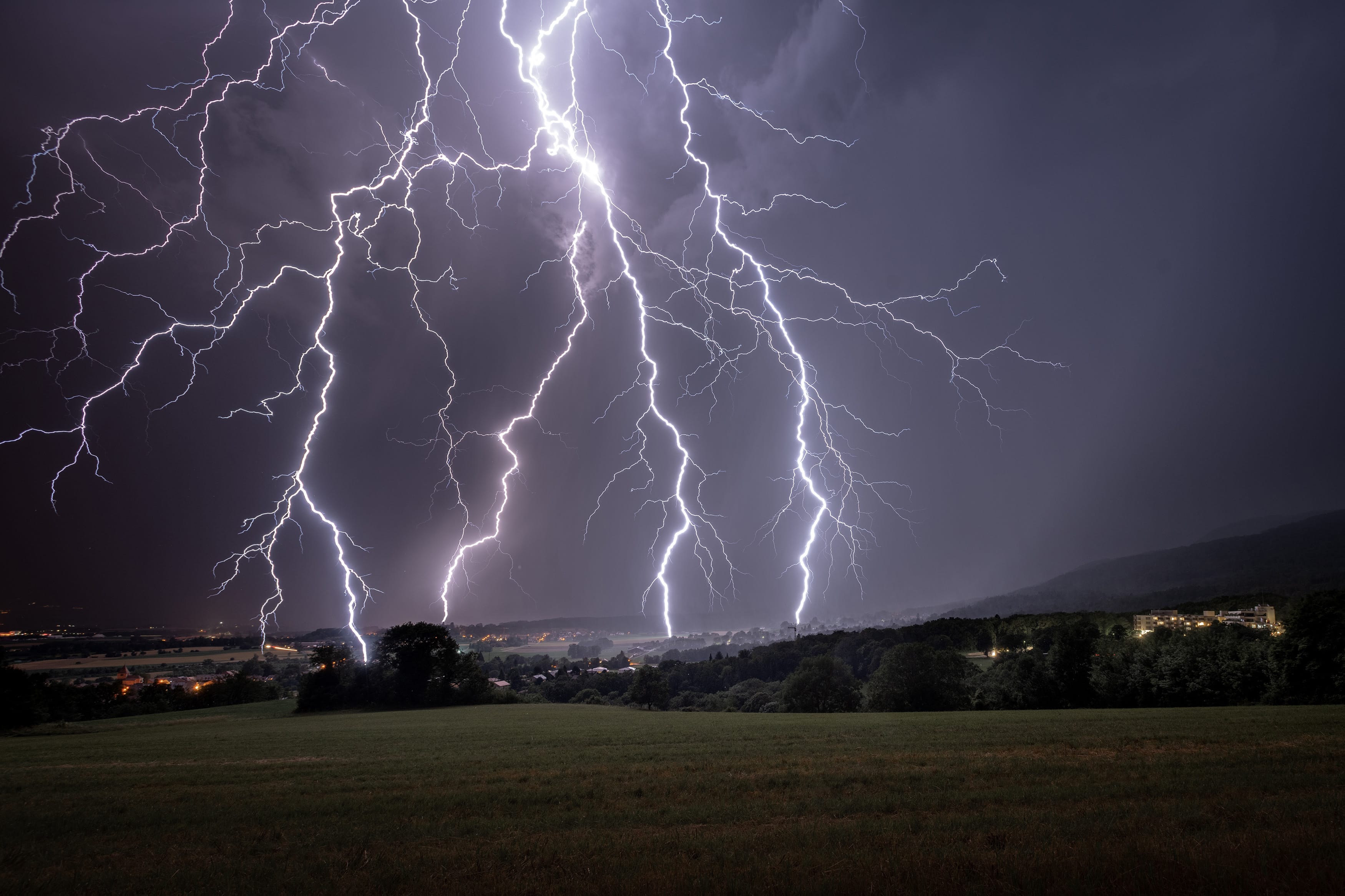 Ma première chasse à l'orage, depuis la commune de Genolier en Suisse en regardant vers Genève. L'orage a passé les crêtes du Jura et est venu droit sur moi avant de continuer sur les hauts de Lausanne en suivant le bord du lac Léman
C'est l'impact le plus proche et le plus impressionnant que j'ai eu hier soir. Je précise que les 5 ramifications sont tombées en même temps.
EXIFs: 30' f8 200iso D850 17-35mm à 17mm - 07/07/2019 01:36 - Samuel Nugues