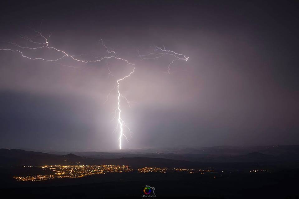 Impact de foudre légèrement ramifié avec en premier plan, la Ville d'Issoire. Capturé du Pic d'Ysson, il marque l'un des derniers impacts que la cellule orageuse laissera éclater, avant de se dissiper. - 08/08/2018 22:00 - Vent des Ciels