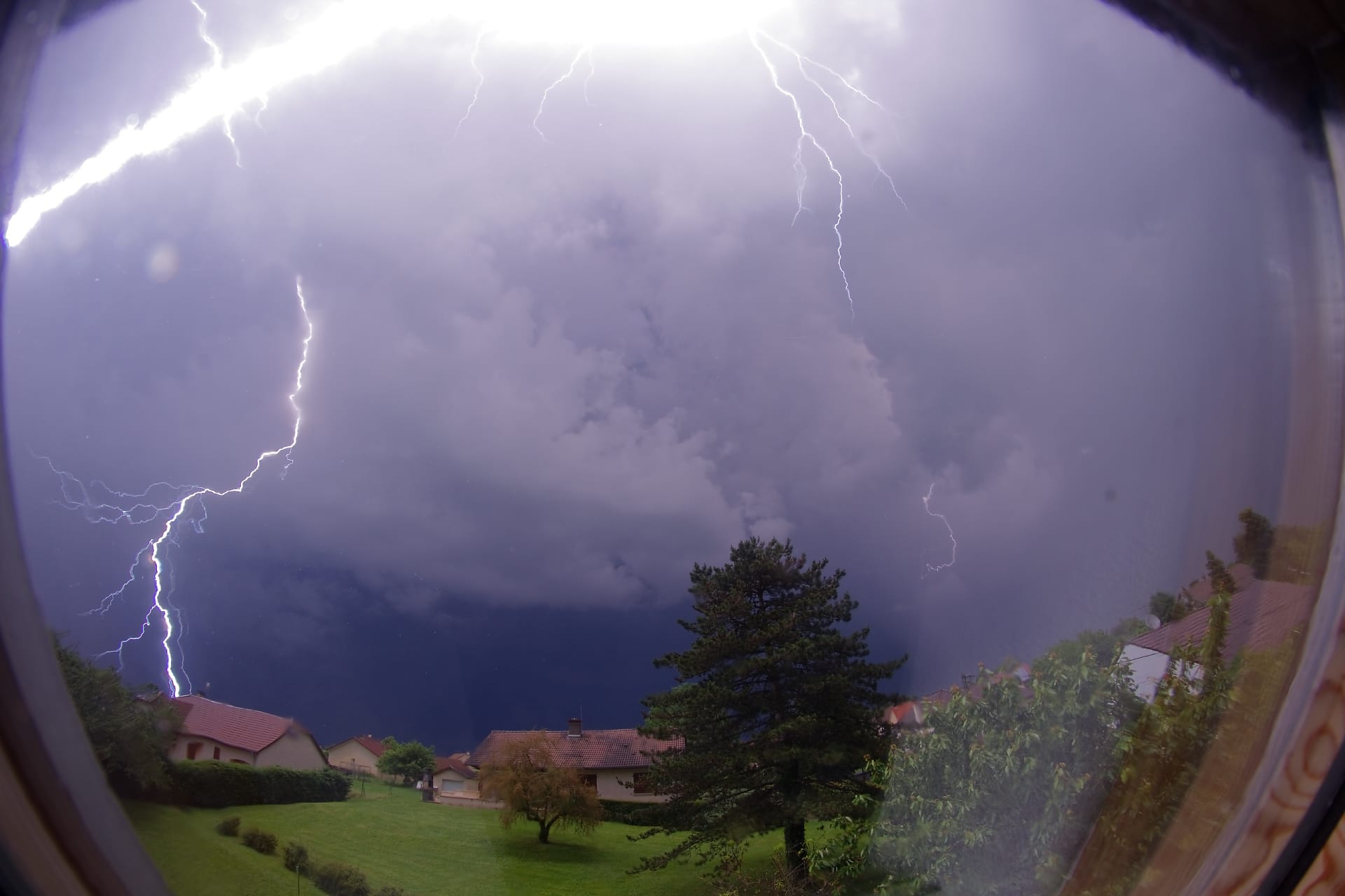 Un orage est passé ce mardi soir, en milieu de nuit, derrière le Mont Roland.
La pluie étant trop intense, j'ai décidé de faire mes prises de vue depuis le vélux de mon bureau, d'où l'image un peu 'baveuse'. 
Vers minuit passé de 7 minutes, j'entends une énorme explosion dehors, quasiment au même moment que l'éclair, celui-ci est donc tombé très proche de ma position. En découvrant l'image, dans un premier temps, je pensais que c'était l'éclair qu'on voit tombé au plus loin sur la gauche. Mais finalement, l'impact était tellement proche, que la moitié supérieure de l'image étaie pratiquement saturée sur l'image de preview. Après tirage vers le bas des hautes lumière, je découvre l'éclair recherché en haut de l'image.
Image prise avec un canon 1300D, muni d'un objectif grand angle fisheye 8mm. - 29/05/2018 00:07 - Nicolas Rossetto