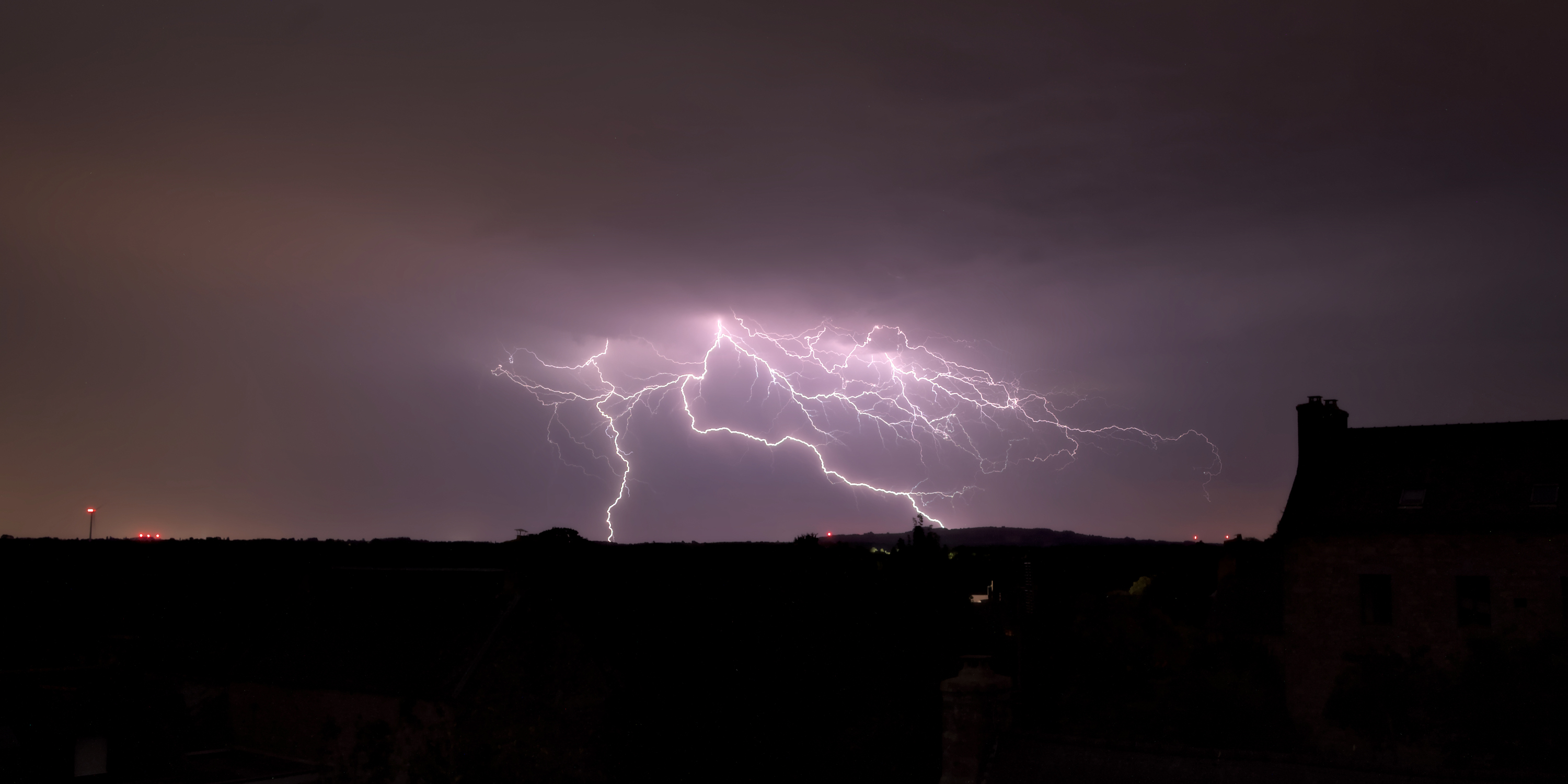 Une ligne orageuse remonte par le Morbihan et arrive dans les Côtes d'Armor en milieu de nuit. L'image est une superposition de deux photos prises à quelques minutes d'intervalle aux alentours de minuit et demi. La foudre tombe à plusieurs reprises au sud du Menez Bré, entre Louargat et Bourbriac. - 14/08/2022 00:33 - Julie Cotinaud