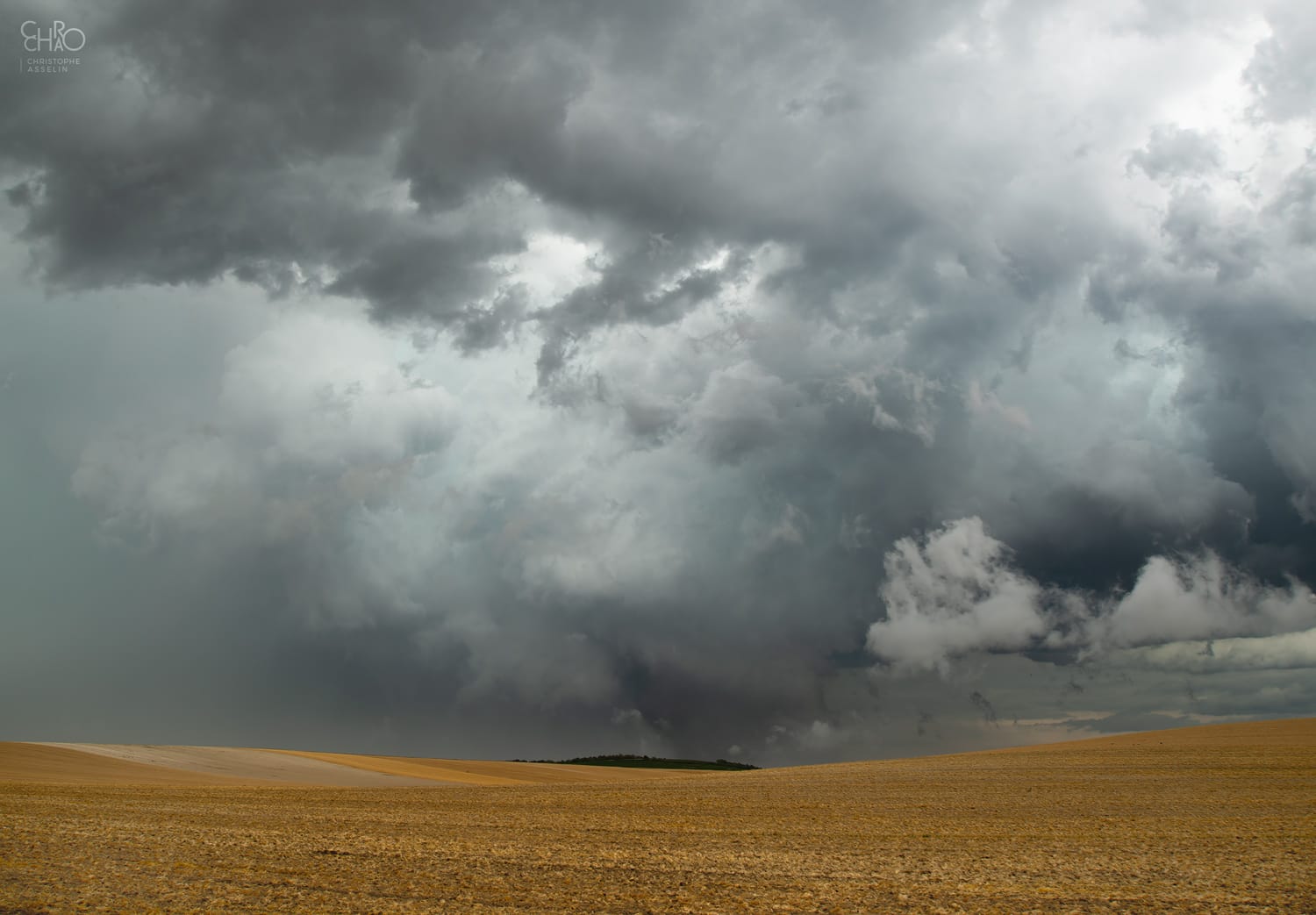 Probable tornade dans la Marne au nord du village de Bassuet. Cette supercellule dantesque a provoqué plusieurs phénomènes tourbillonnaires de type "gustnado" sur son bord sud, mais cette photo montre une rotation plus franche et plus large même s'il est difficile d'être certain que le contact avec le sol a eu lieu à cette distance. On note cependant la superbe fente claire liée au RFD (Courant descendant arrière de l'orage) qui s'enveloppe autour du mésocyclone. - 09/08/2019 15:43 - Christophe Asselin