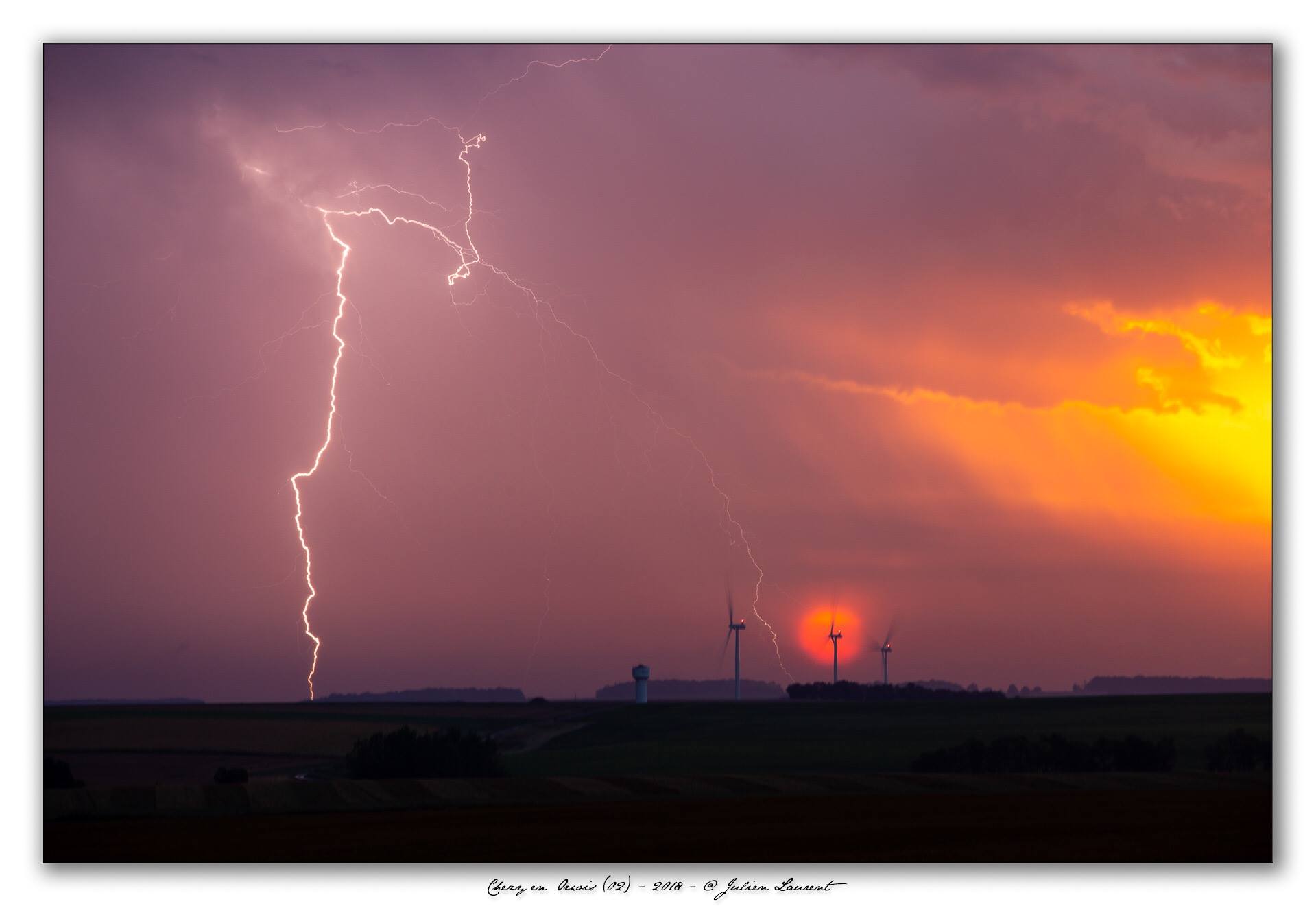 Eclair + le soleil levant + soleil dans l’axe de l’éolienne + éclair bien cadré dans un 200mm, le tout près de Chézy-en-Orxois (02) - 29/08/2018 07:00 - Julien Laurent