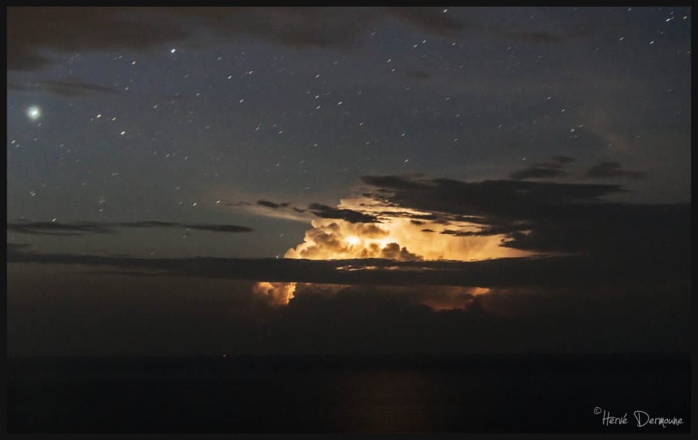 Orage au large du Var, à environ 150 km de là, près de la côte occidentale de la Corse qui a éclaté à partir de 04h.
Une belle structure nuageuse (Cumulonimbus massif) et de nombreux flashs visibles et parfois un canal (éclair) malgré la distance. - 31/08/2016 06:00 - Hervé DERMOUNE